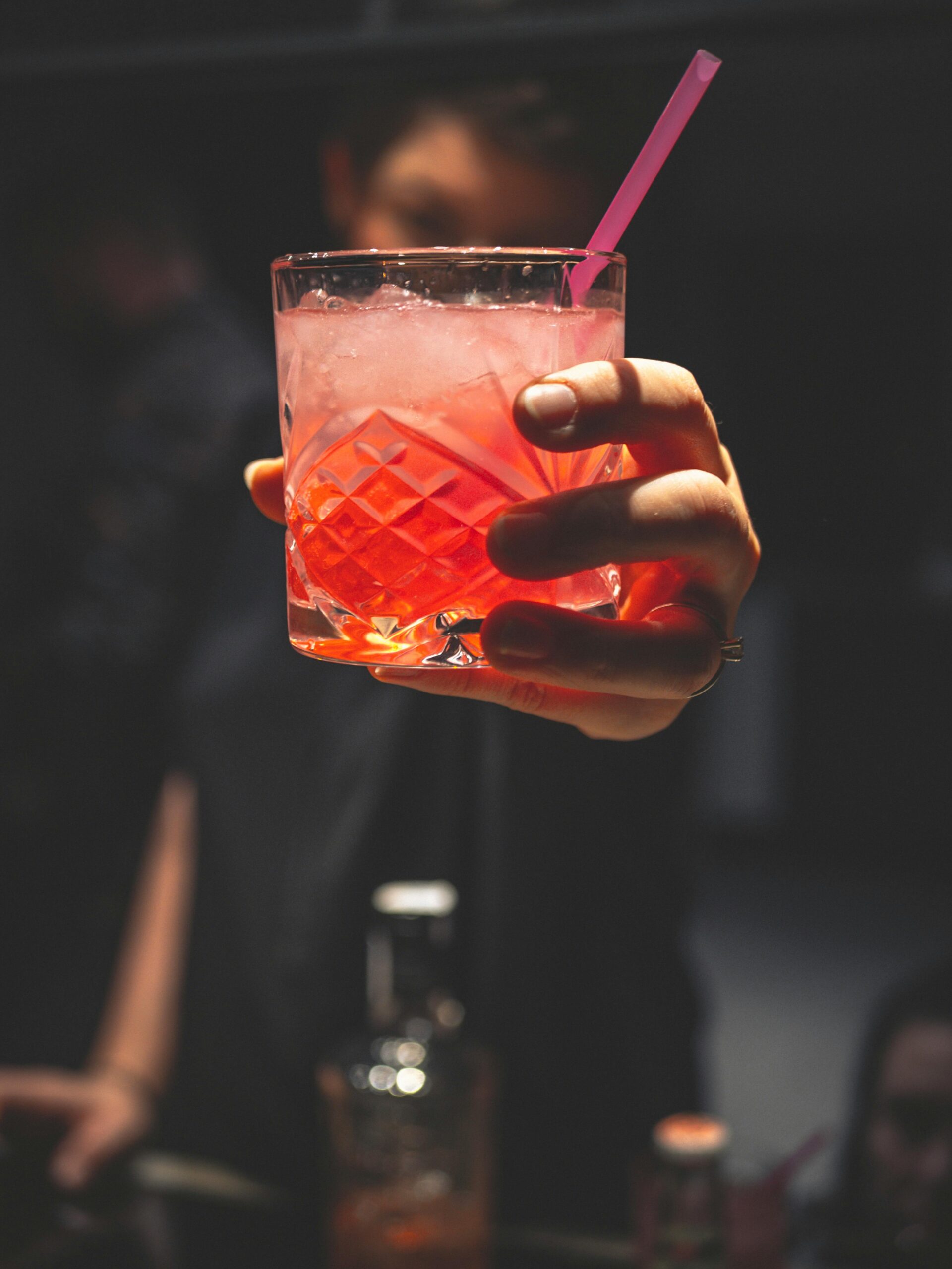 Hand holding a cocktail at a rooftop bar