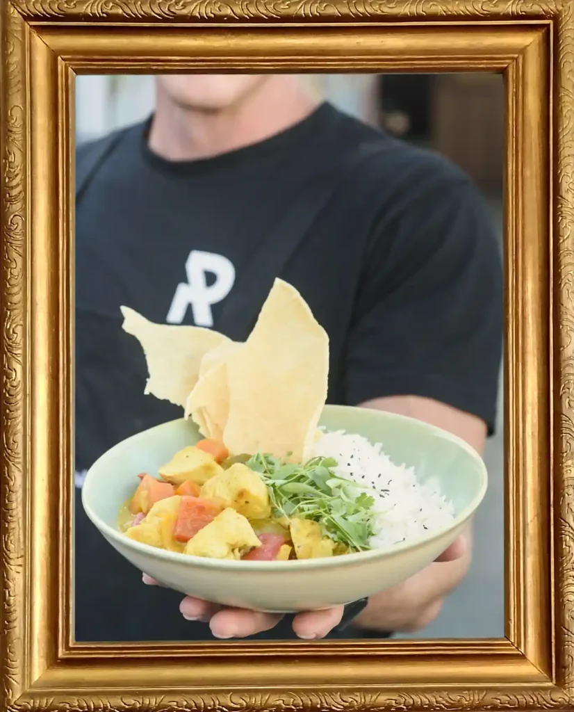 Server holding a bowl of Bombay Curry Selection