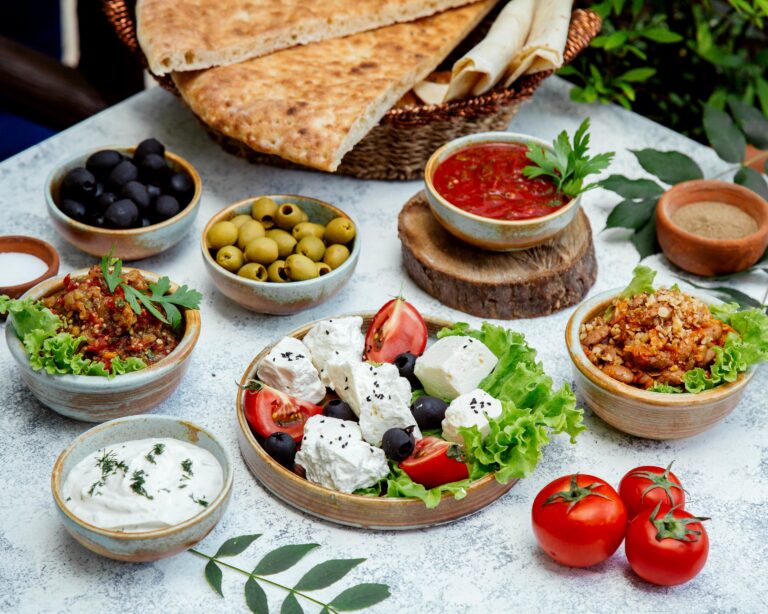 Traditional Cypriot appetizers including feta cheese, olives, tzatziki, and fresh tomatoes with pita bread