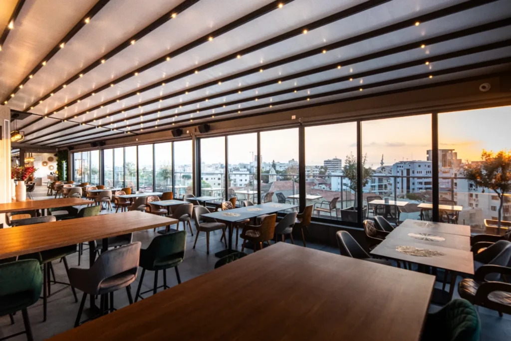 Rooftop restaurant interior with sunset view over Larnaca city