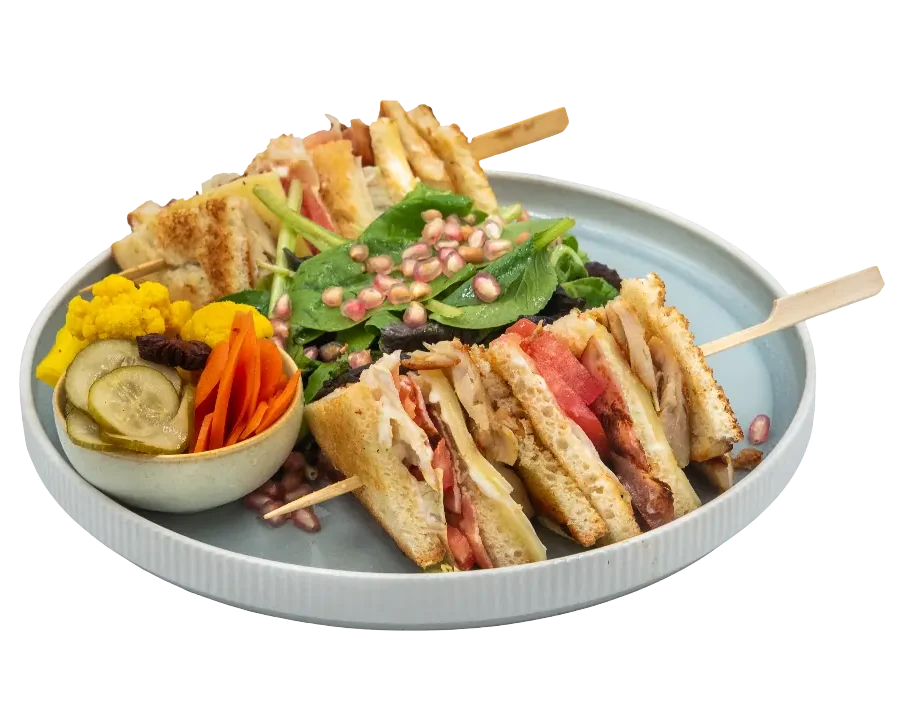 gourmet club sandwich with chicken, bacon, cheese, fresh vegetables and pickled garnish in larnaca
